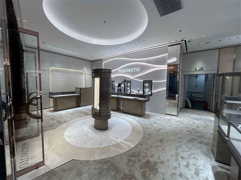 Jewelry counters arranged around a central feature display establish a clear visual focus while maintaining comfortable circulation through the main retail area.